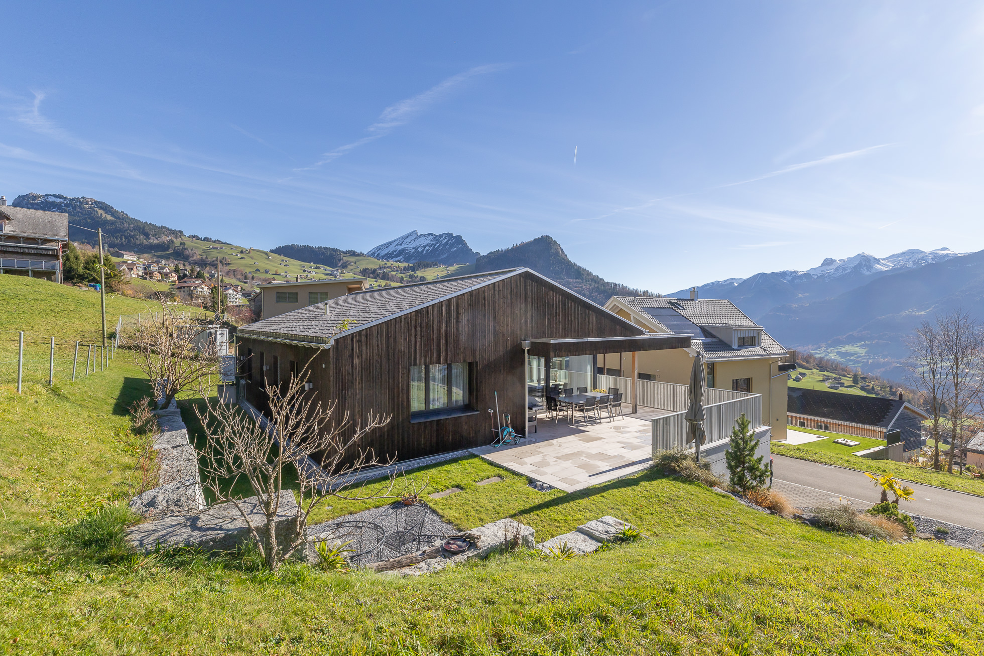 Moderne Berghaus-Ansicht mit Terrasse und Alpenpanorama