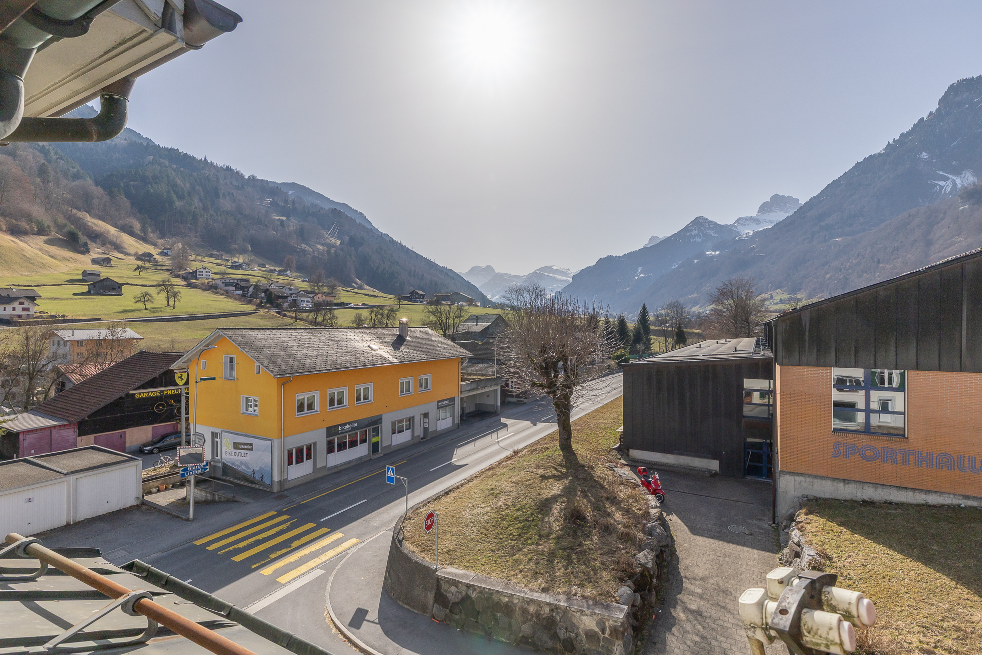 Alpenblick über ein Tal mit Straße und Gebäuden