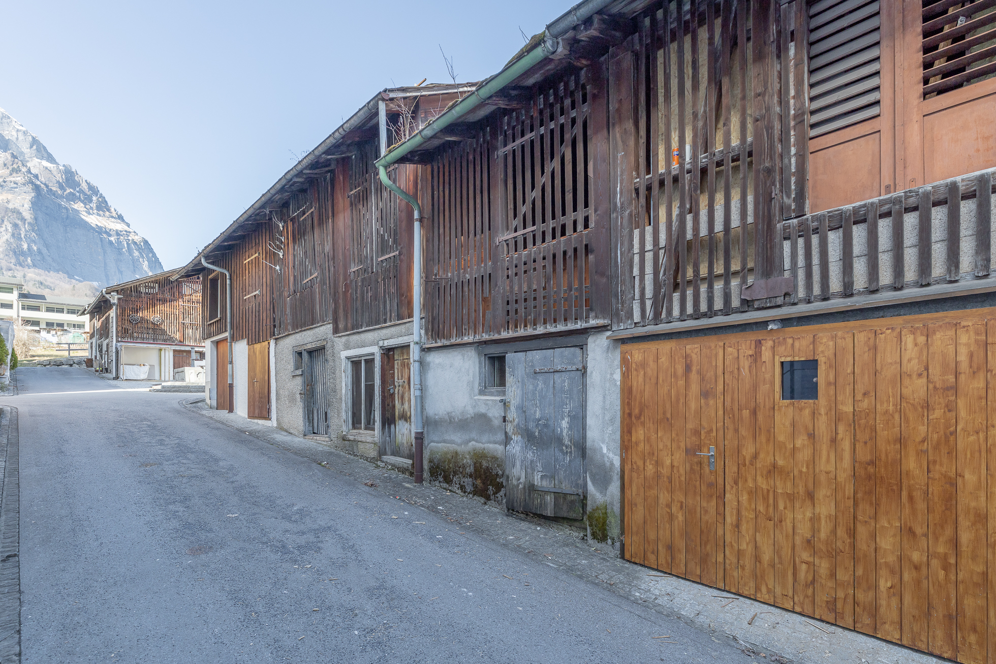 Rustikale Alpin-Fassade an einer schmalen Straße