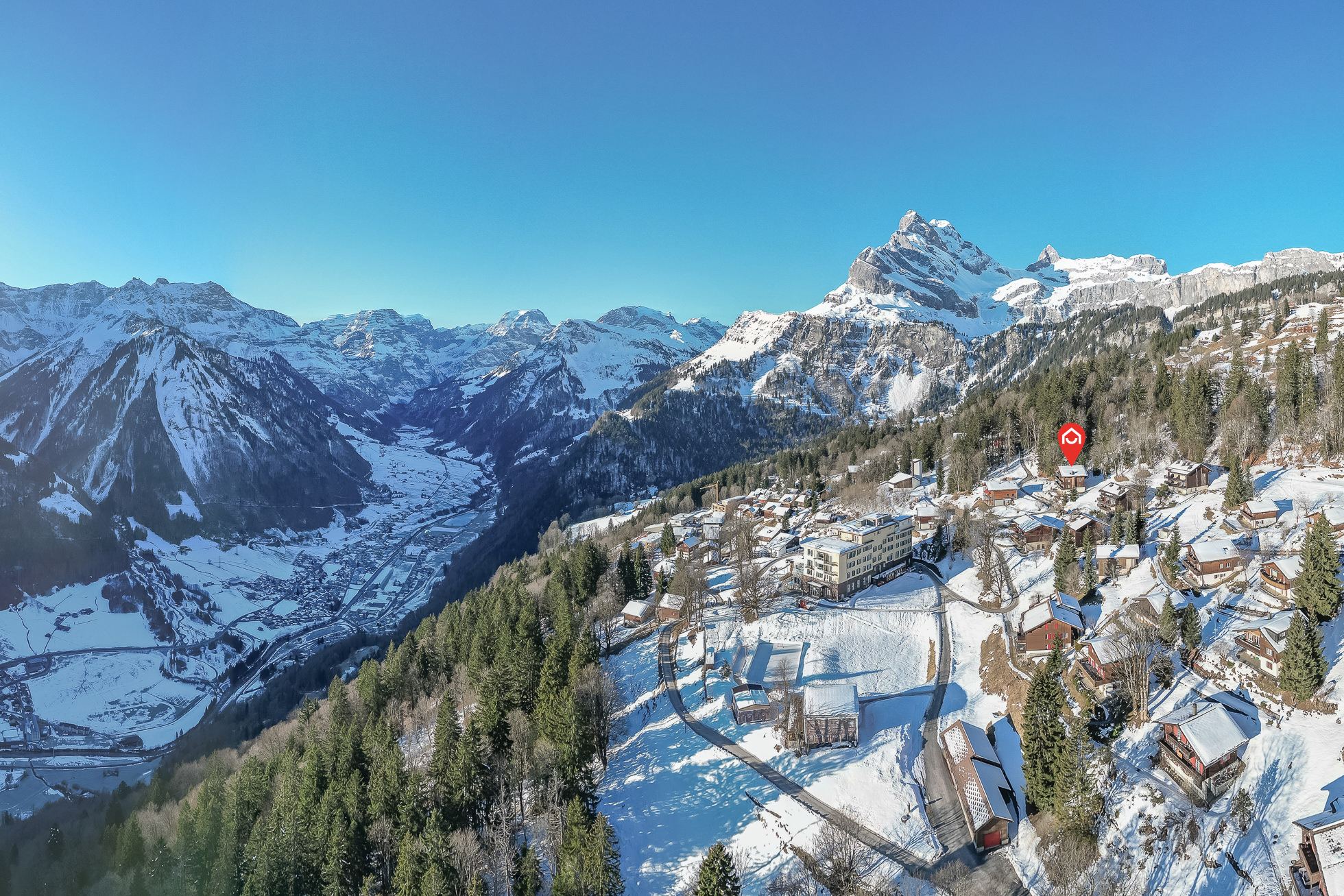 Schneebedeckte Berglandschaft mit Siedlung