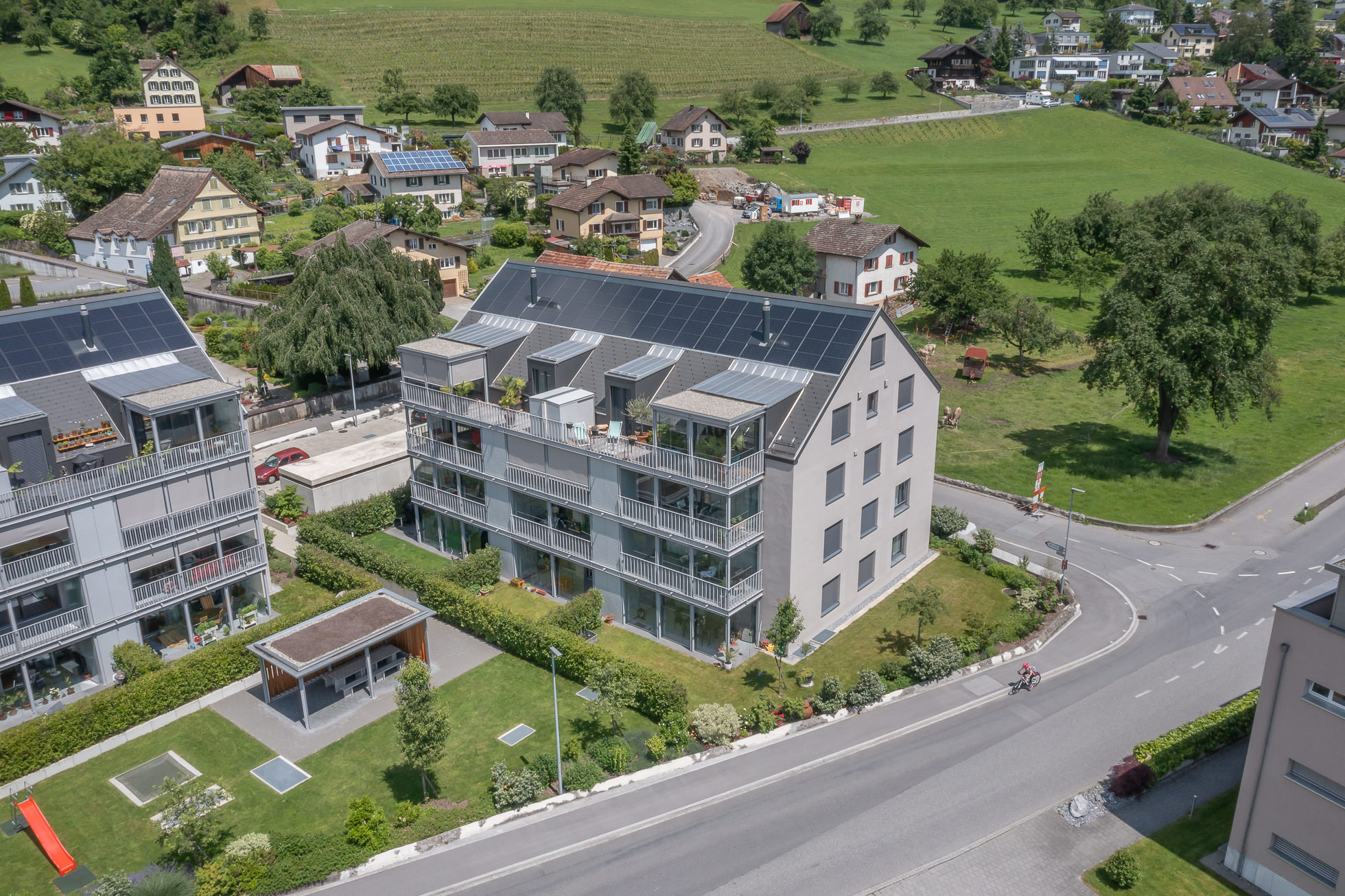 Luftaufnahme einer modernen Wohnanlage in grüner Hanglage
