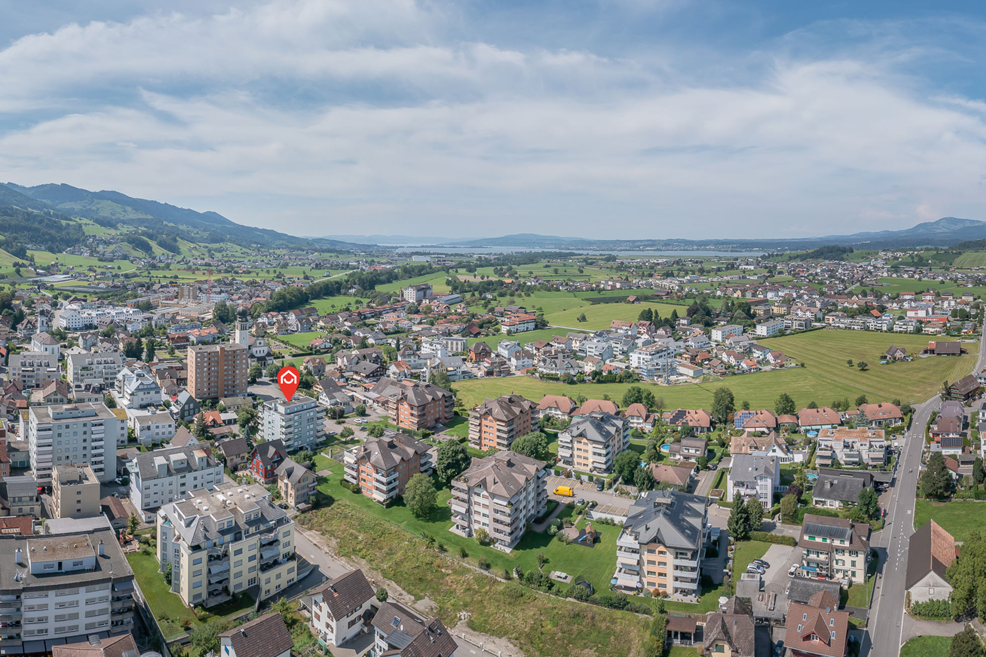 Luftaufnahme einer Wohnsiedlung mit Berg- und Seeblick
