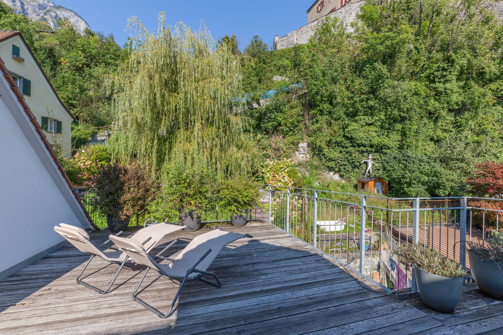 Terrasse mit Liegestühlen und Gartenblick