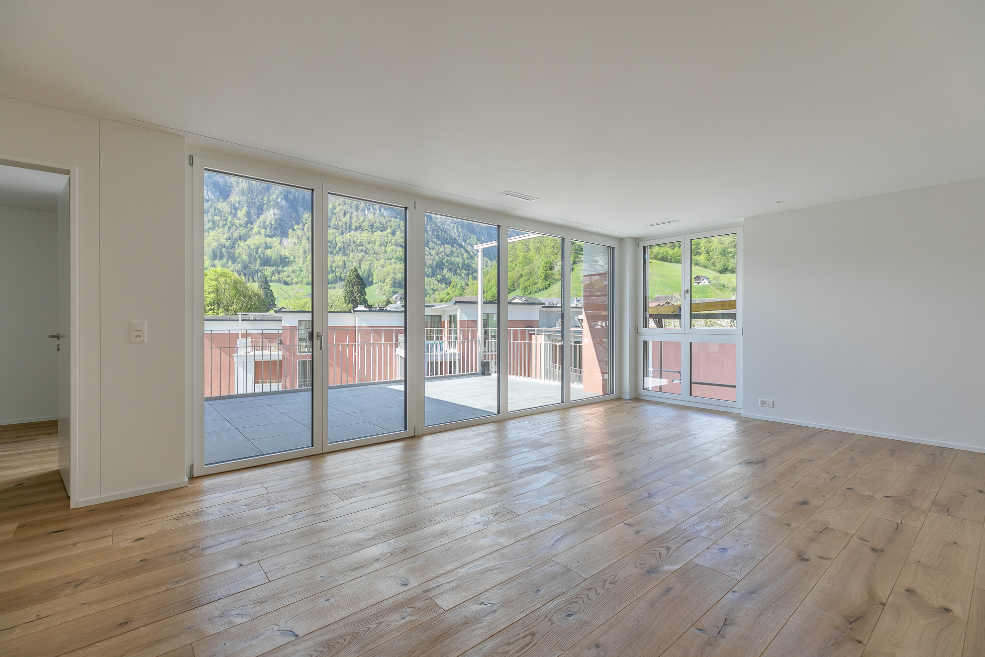 Heller Wohnraum mit Panoramafenstern und Bergblick