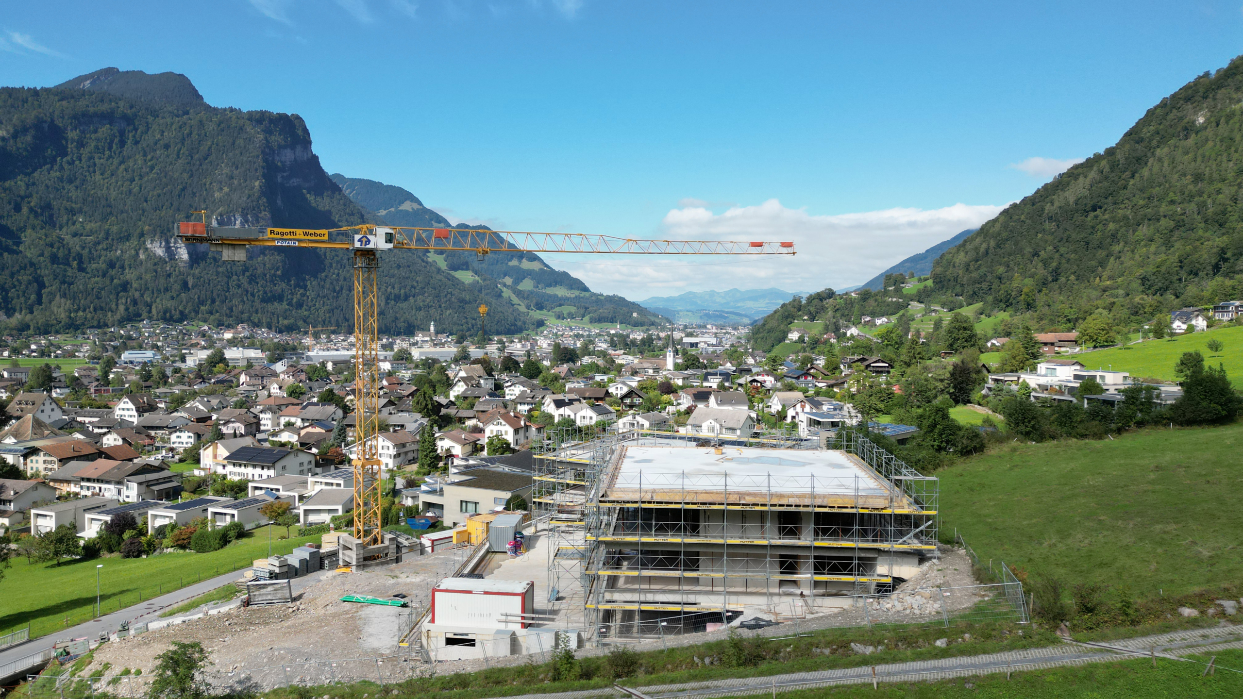 Baugelände mit Kran und Bergpanorama