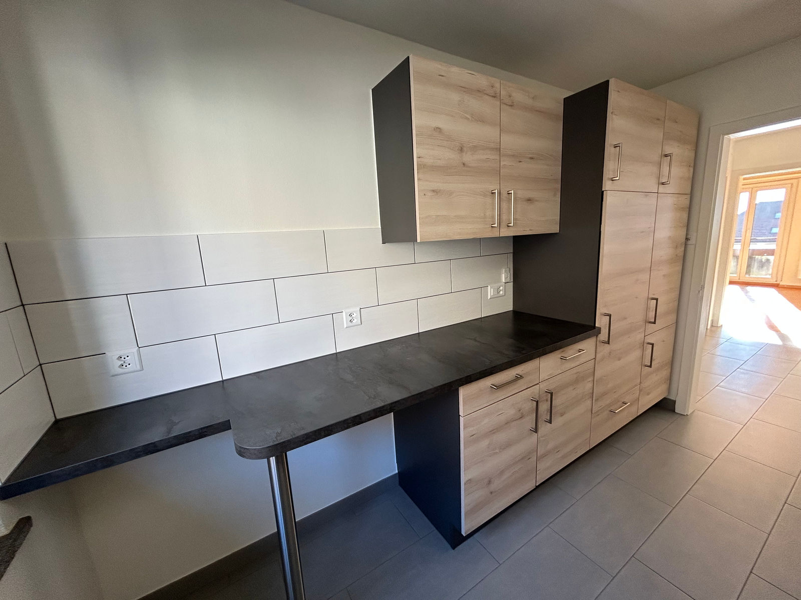 Küche mit dunkler Arbeitsplatte und Holzfronten