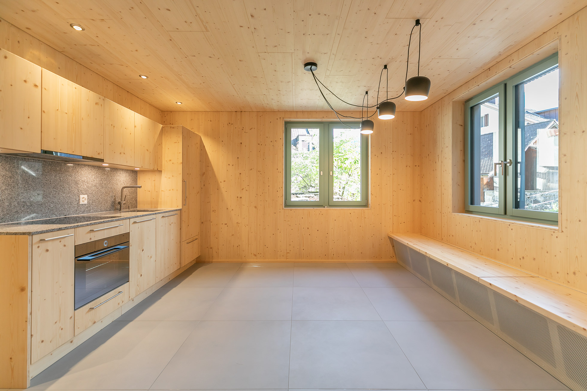Helle, holzverkleidete Küche mit großen Fenstern