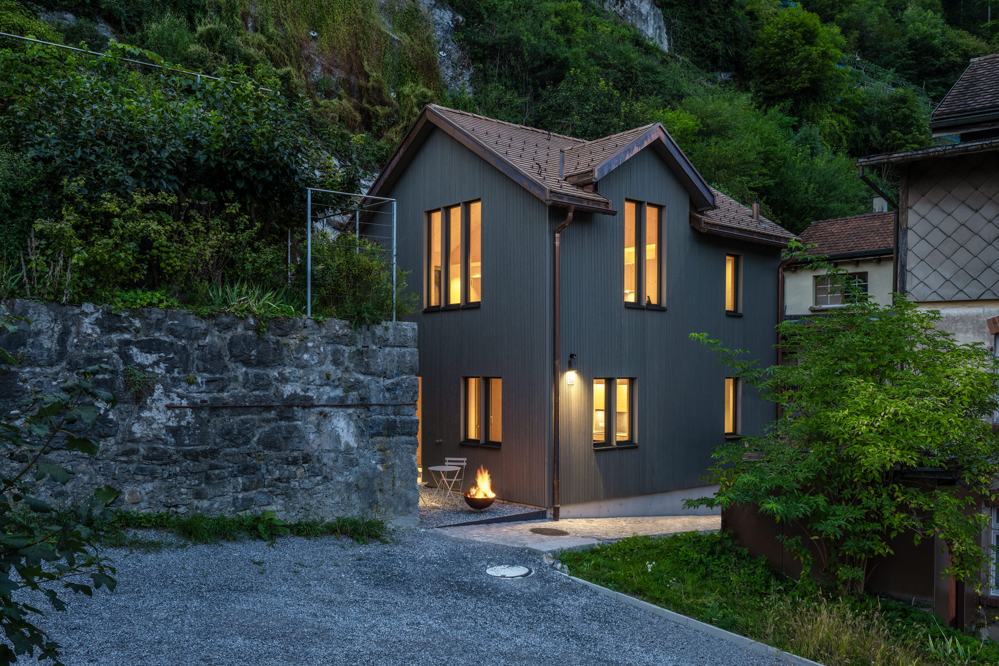 Exterieur eines Hauses in Hanglage bei Abenddämmerung