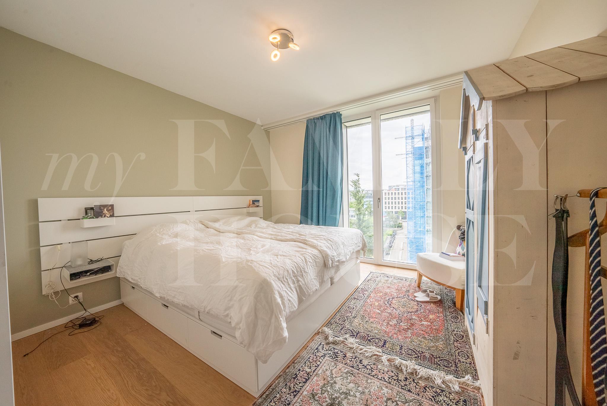 Helles Schlafzimmer mit Fensterfront und Einbaumöbeln