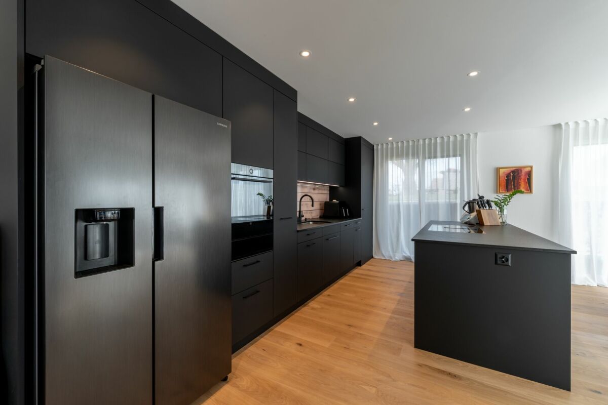 Moderne schwarze Küche mit Kochinsel