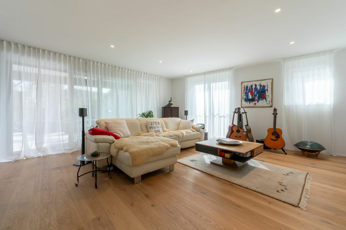 Helles Wohnzimmer mit großer Fensterfront und Musikinstrumenten