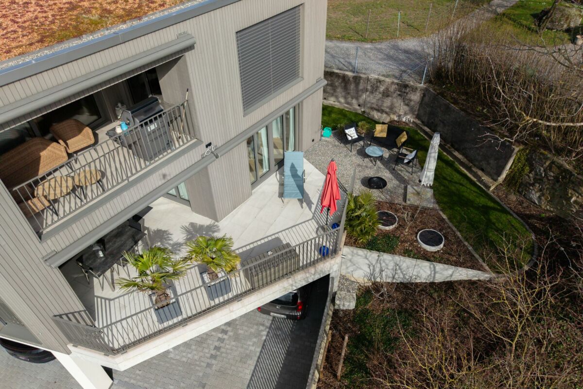 Drohnenaufnahme einer modernen Terrasse mit Balkon und Garten