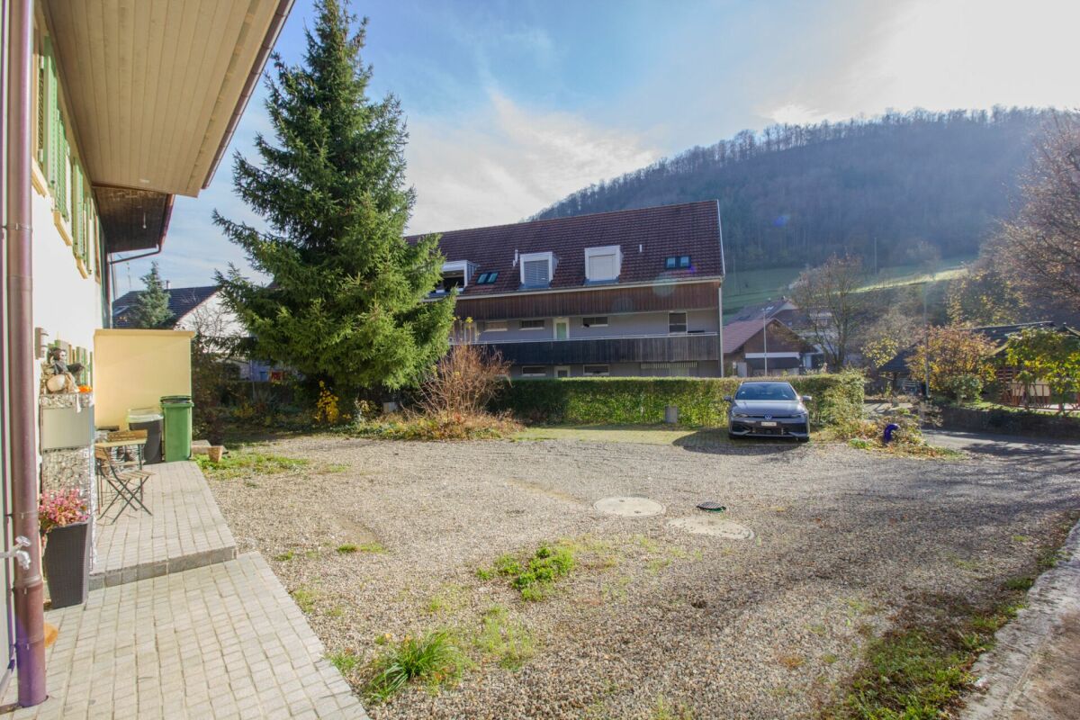 Hausansicht mit Hof und Bergkulisse