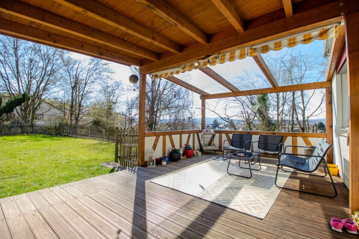 Überdachte Holzterrasse mit Gartenblick