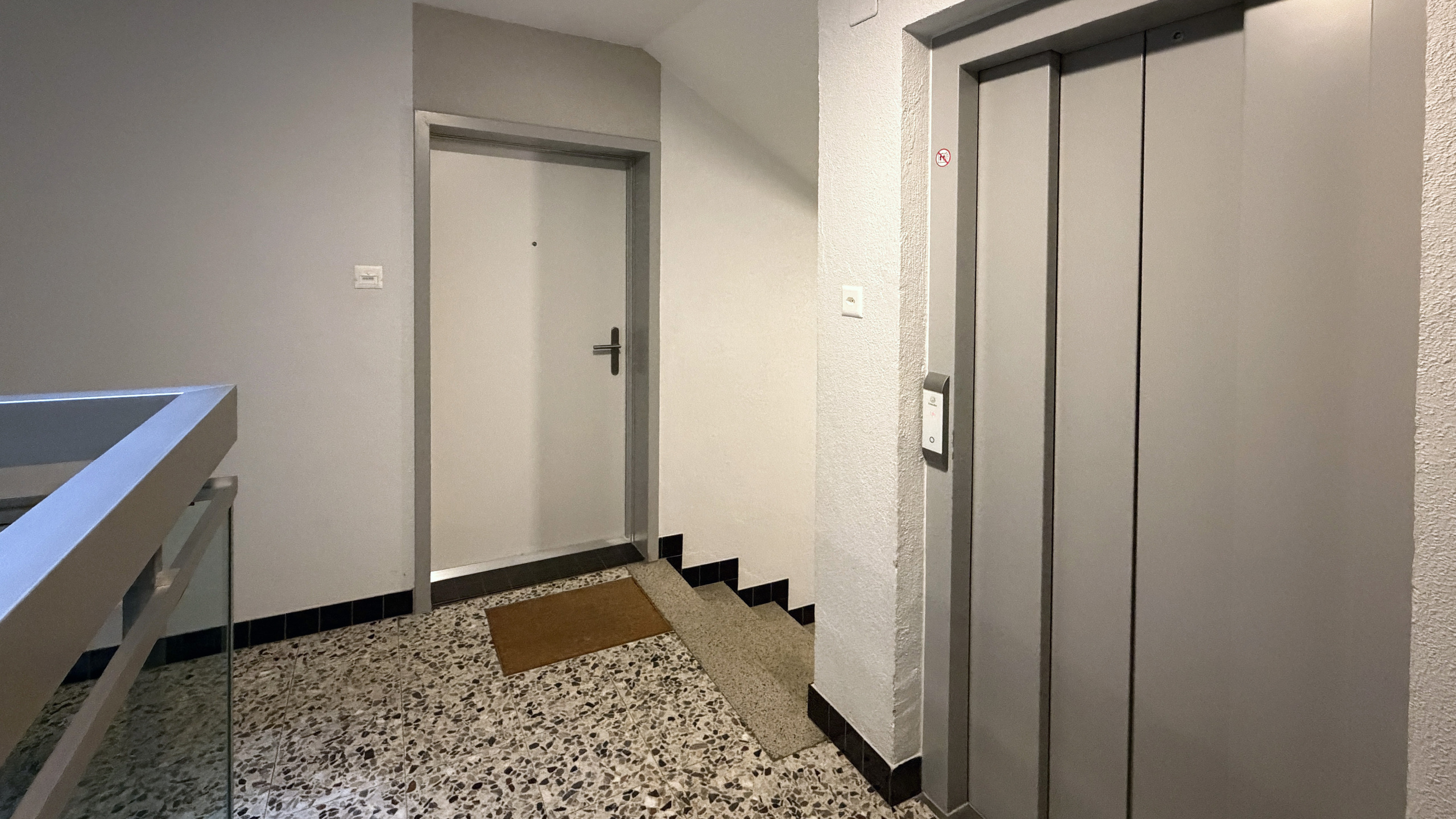 Treppenhaus mit Aufzug und Eingangstür