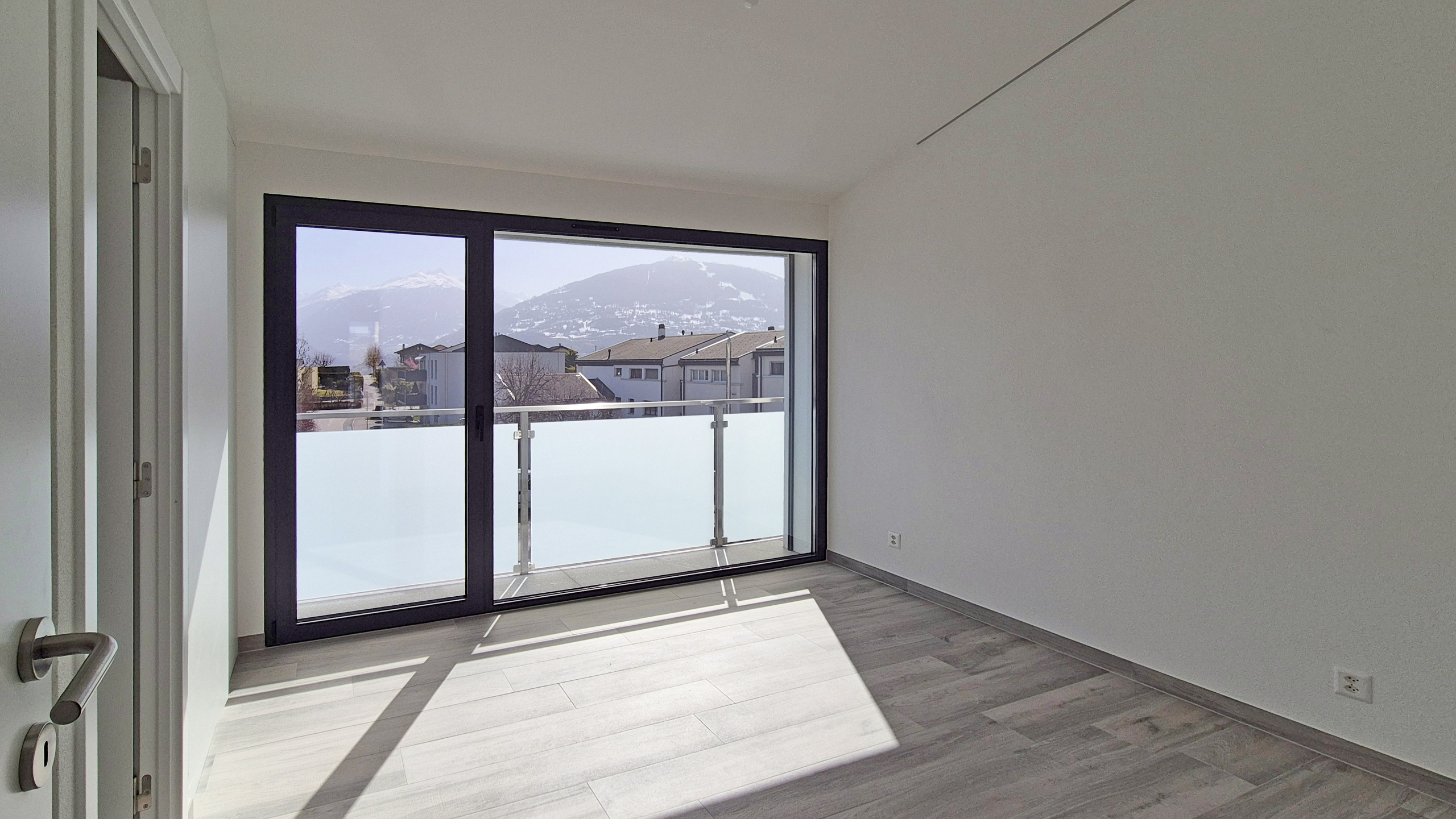Heller Raum mit Balkon und Bergblick