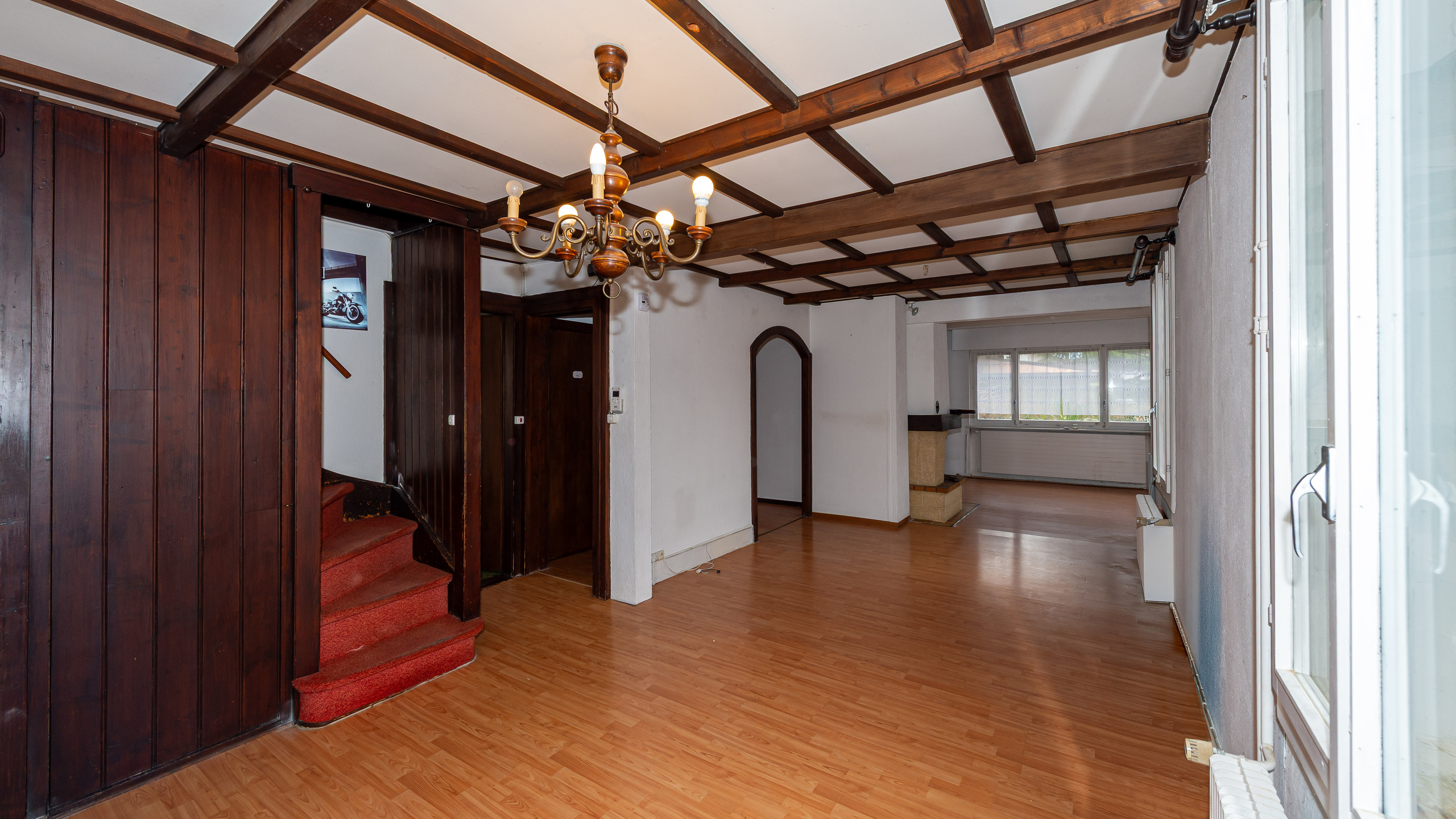 Wohnraum mit Holzdecken und Teppichtreppe