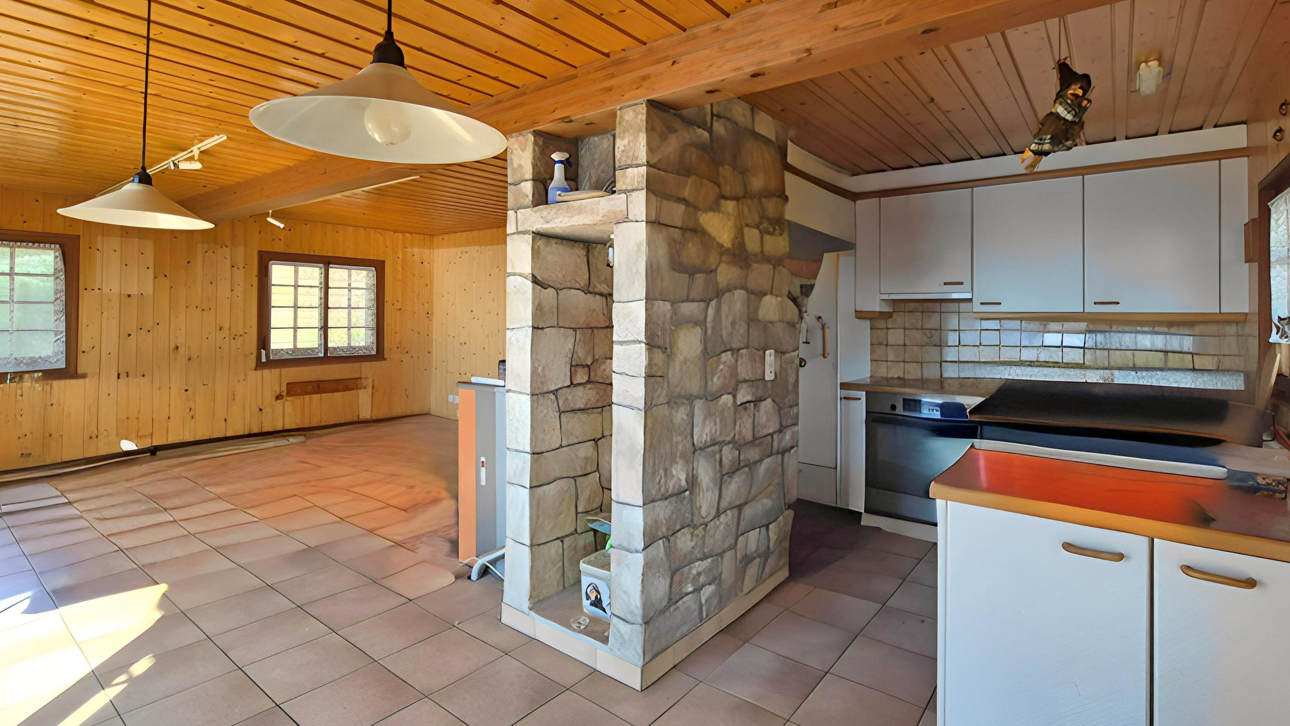 Rustikale Wohnküche mit Holzdecken und Natursteintrennwand