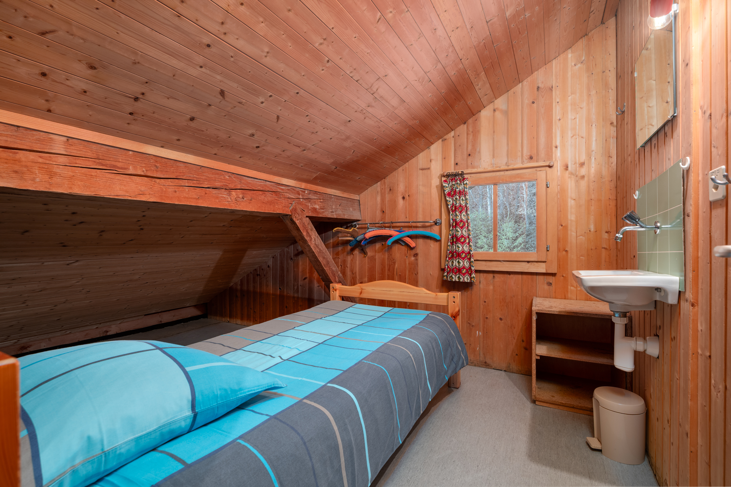 Holzverkleidetes Schlafzimmer mit Waschbereich