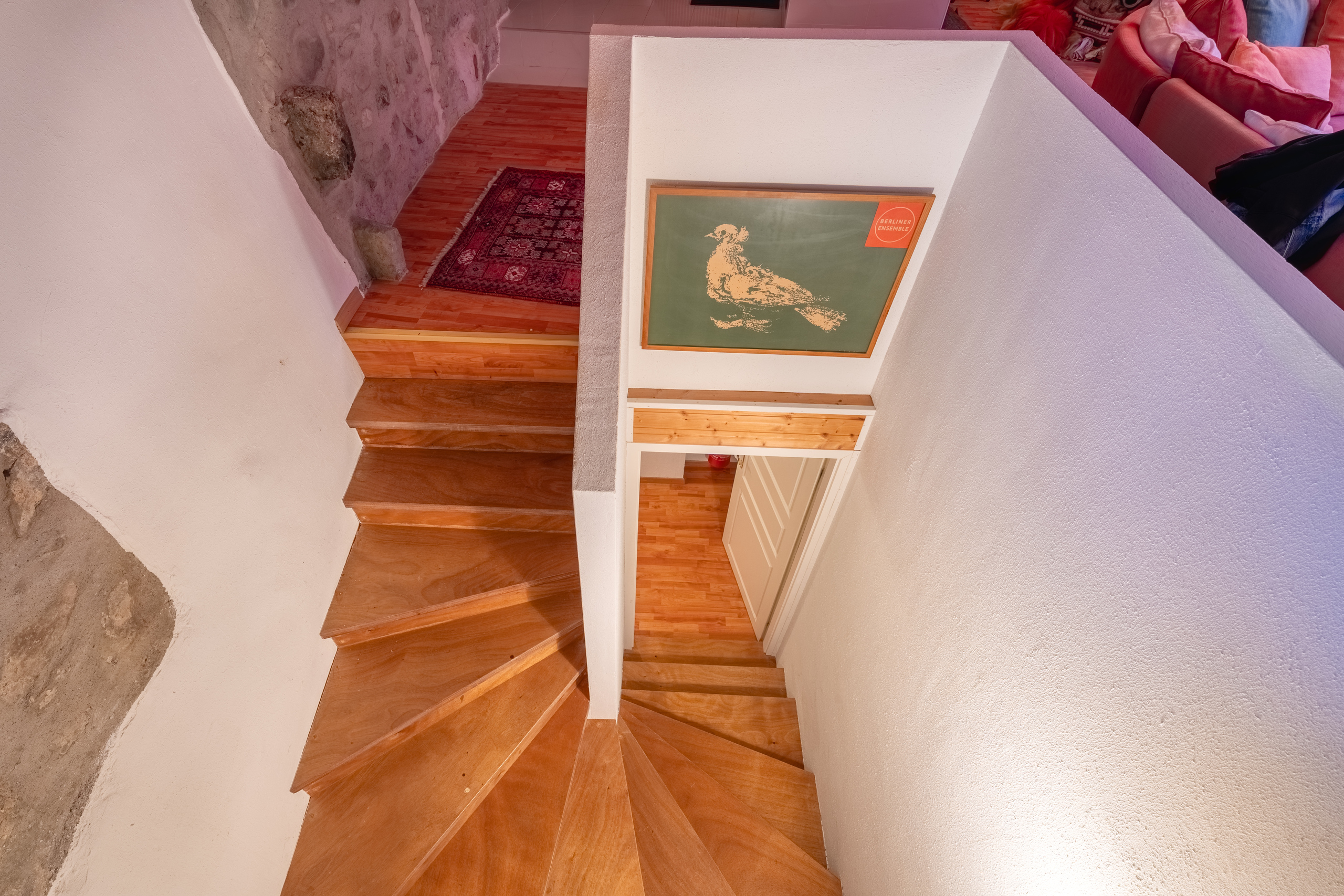 Treppenhaus mit Holzstufen und Sichtsteinwand