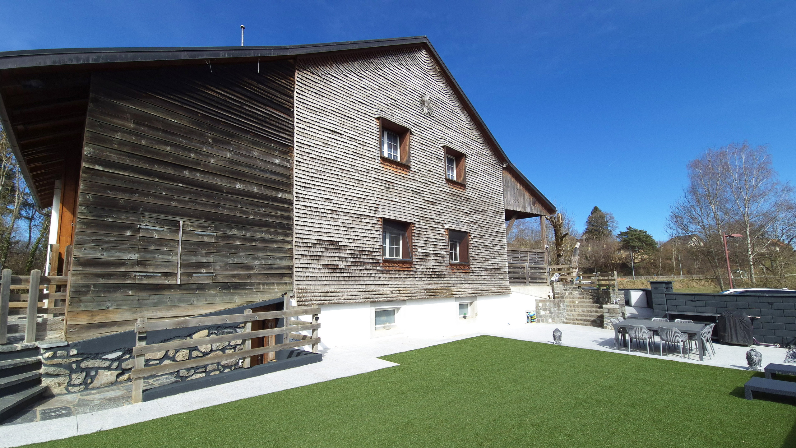 Außenansicht eines Holzhauses mit Garten