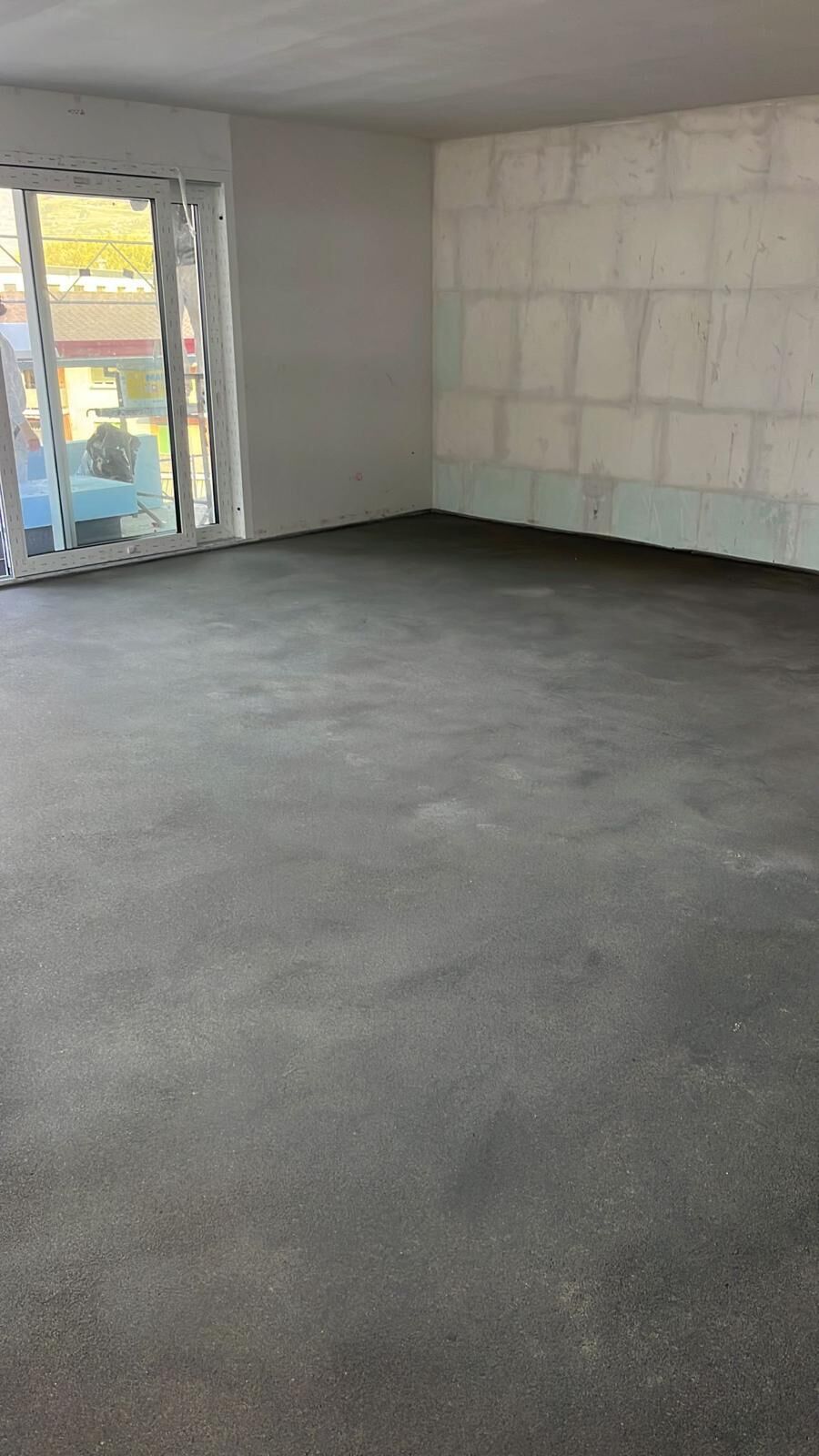 Unfertiger, leerer Innenraum mit Balkonfenster