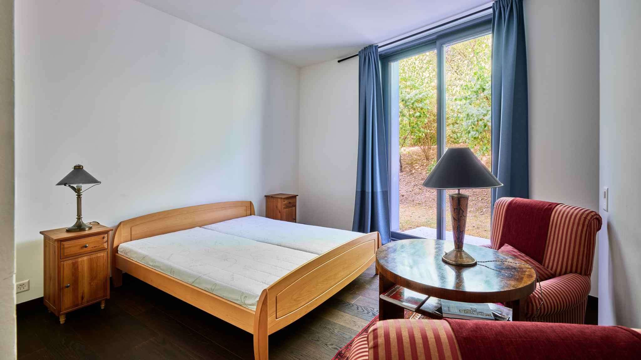 Schlichtes Schlafzimmer mit Blick ins Grüne
