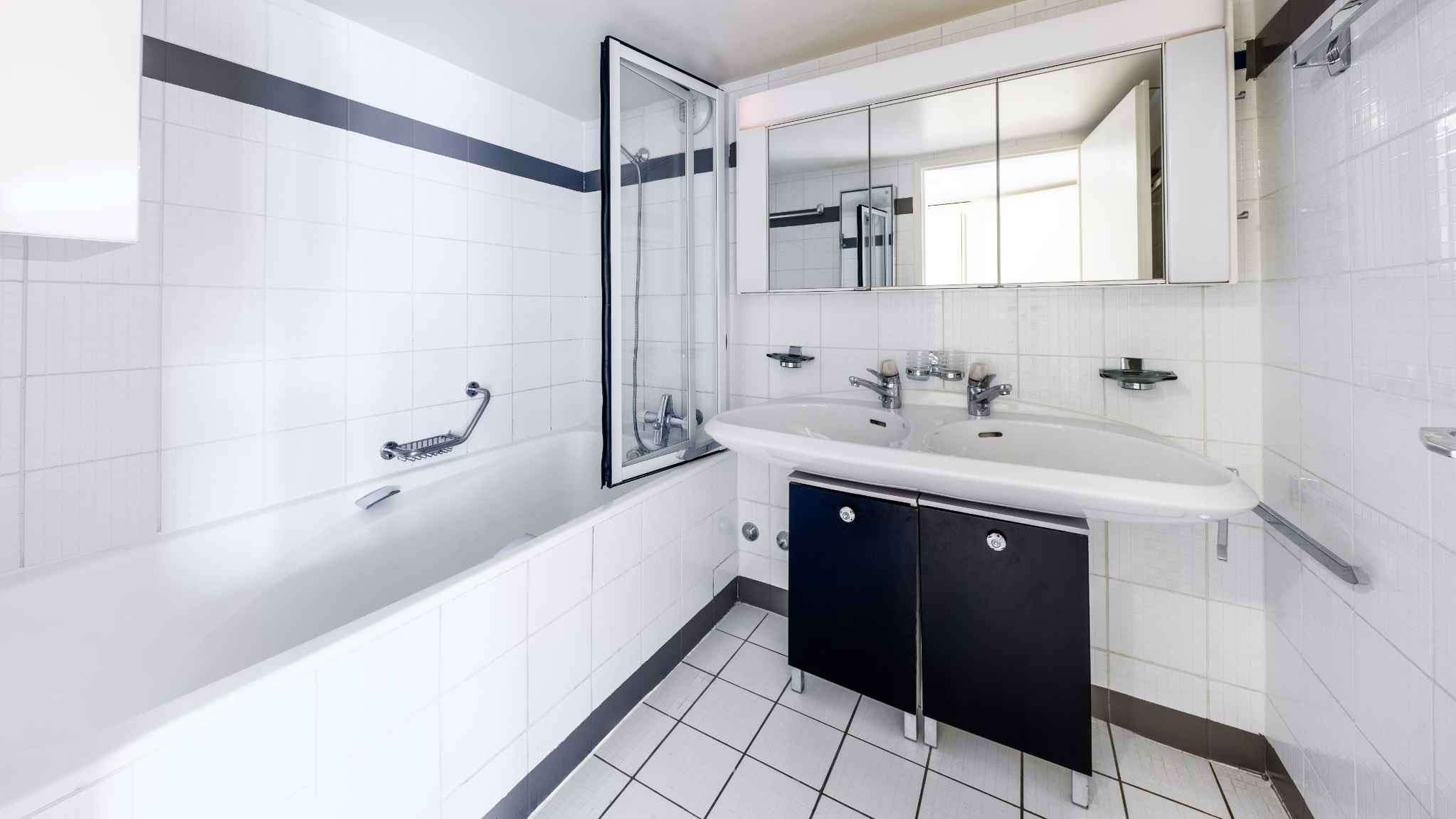 Helles Badezimmer mit Badewanne und Doppelwaschtisch