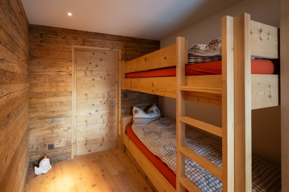 Rustikales Mehrbettzimmer mit Holzbunkbetten