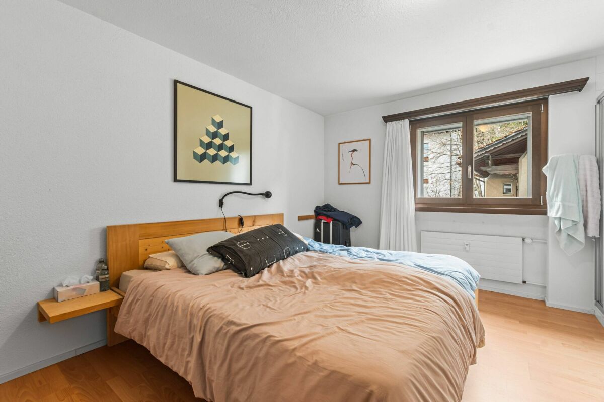 Schlafzimmer mit Holzbett und Fenster