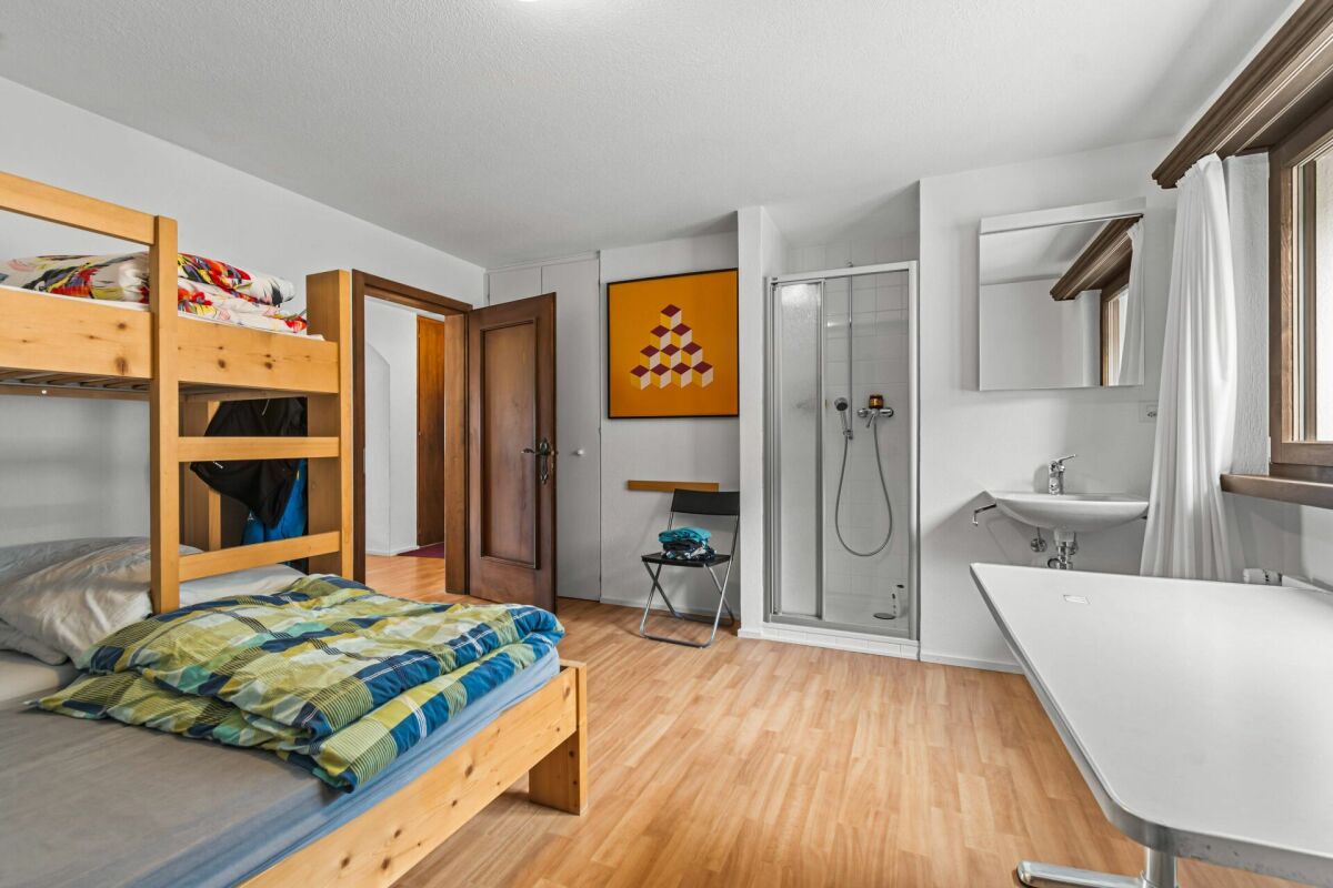 Zimmer mit Hochbett und Badbereich