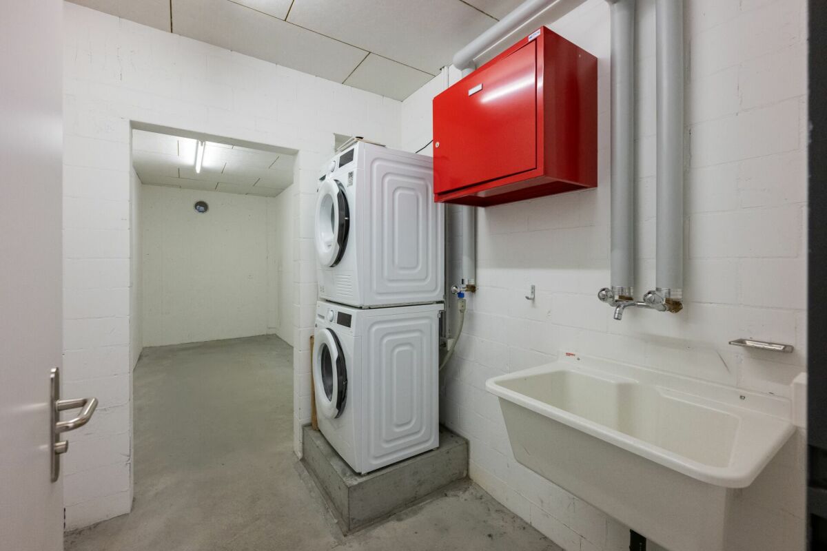 Hauswirtschaftsraum mit Waschmaschine und Ausgussbecken