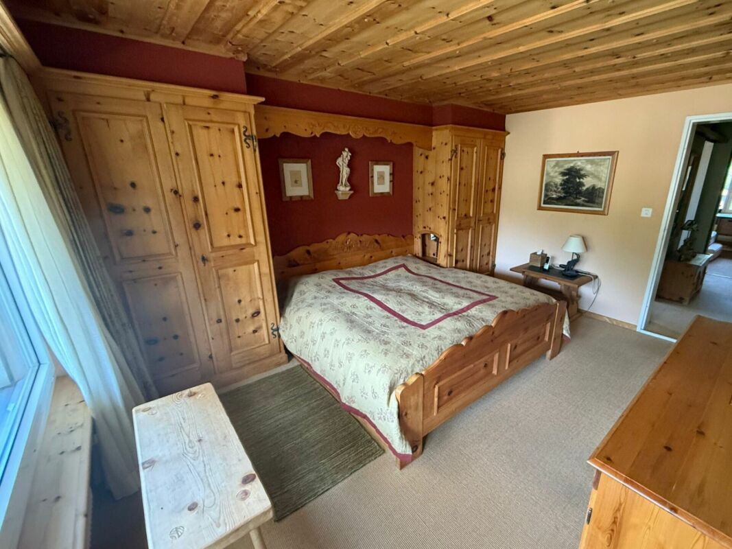 Rustikal eingerichtetes Schlafzimmer mit Holzvertäfelung