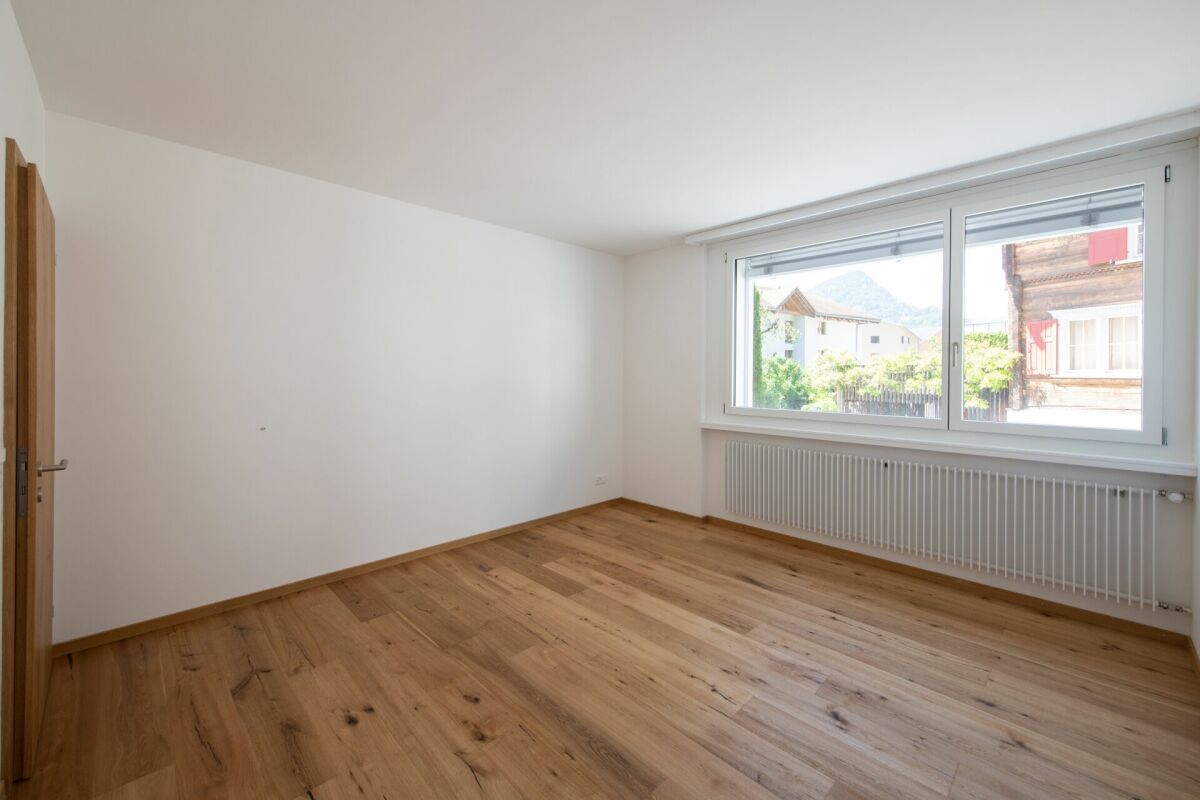 Helles leeres Zimmer mit Holzfußboden