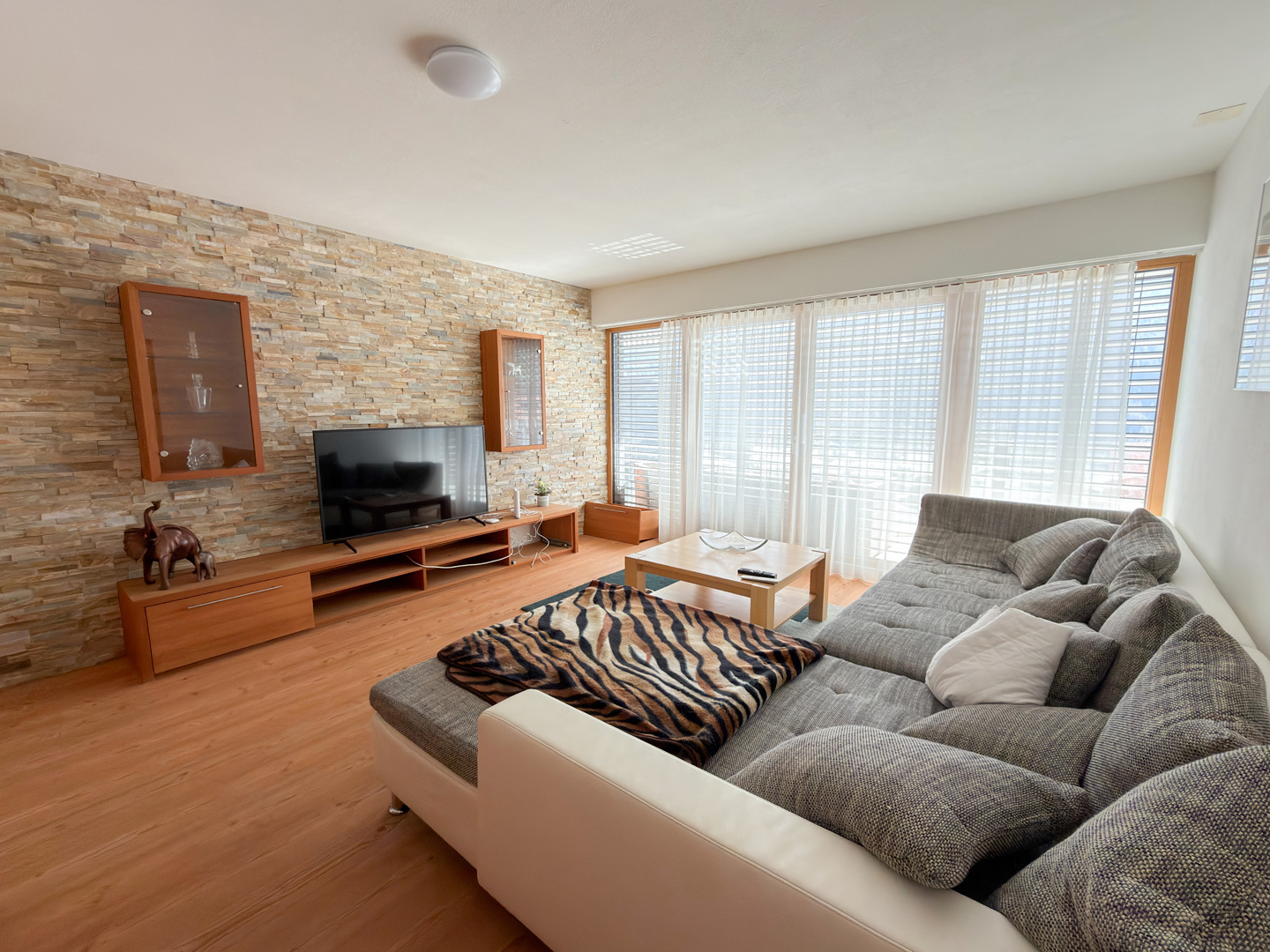 Helles Wohnzimmer mit Ecksofa und TV-Wand