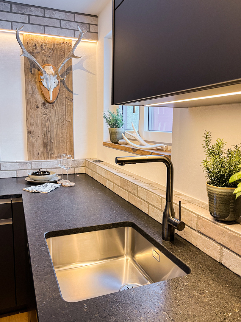 Moderne Küche mit dunkler Arbeitsplatte und Naturdetails