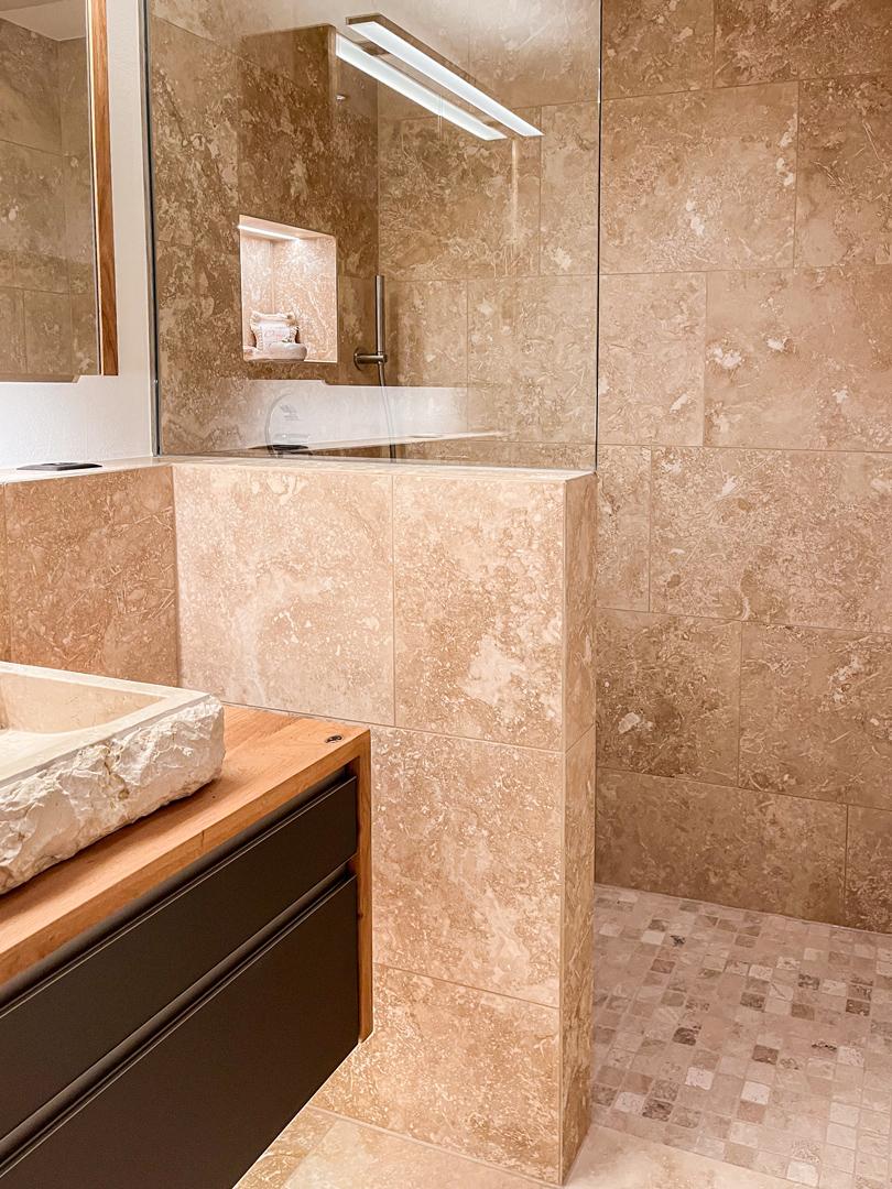 Luxuriöses Badezimmer mit Naturstein und Walk-in-Dusche
