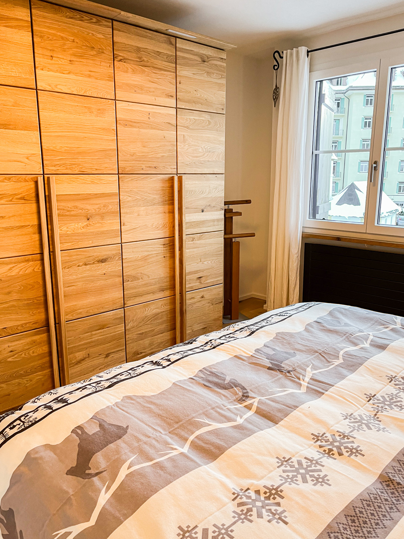 Schlafzimmer mit Holzschrankwand und Fenster