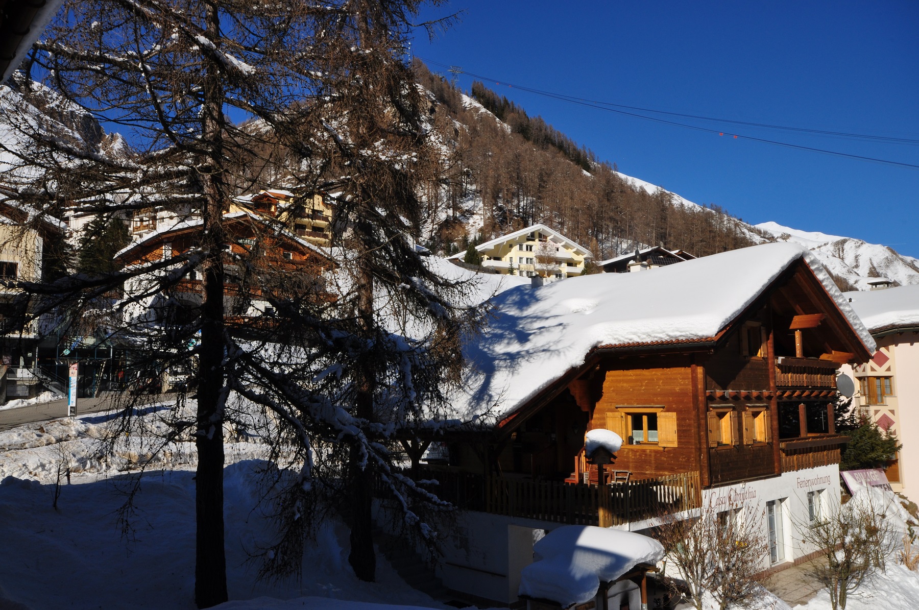 Verschneite Berghäuser im alpinen Tal