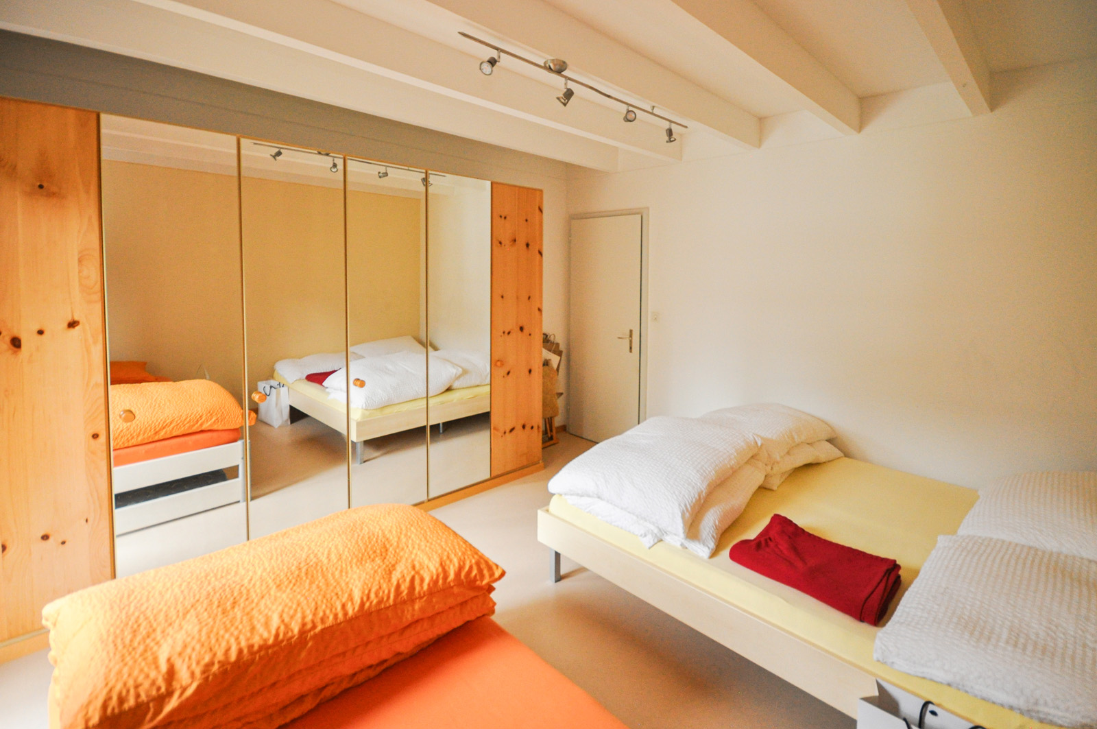 Helles Schlafzimmer mit Doppelbett und großem Kleiderschrank
