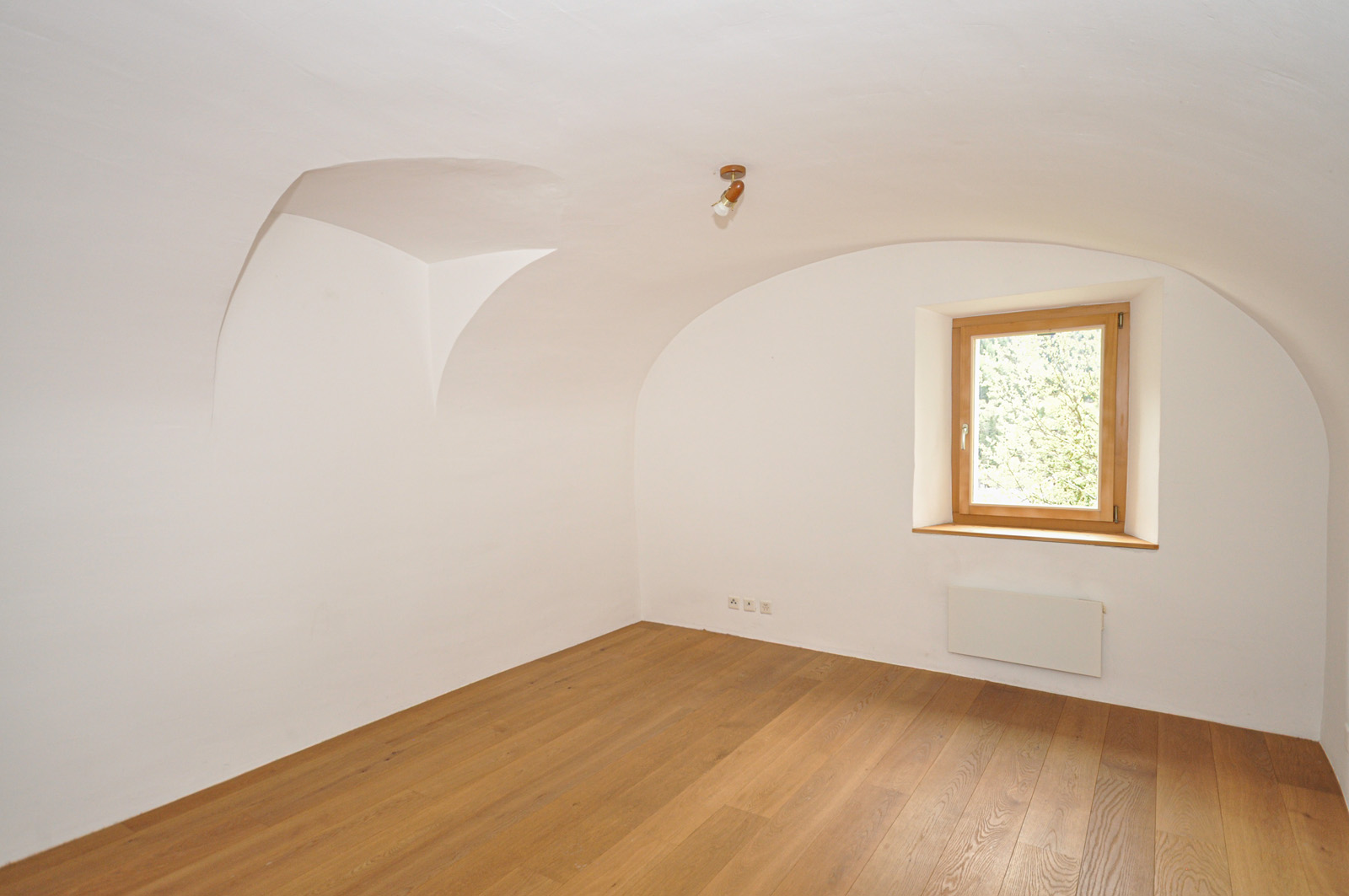 Leerer Raum mit Gewölbedecke und Holzfenster