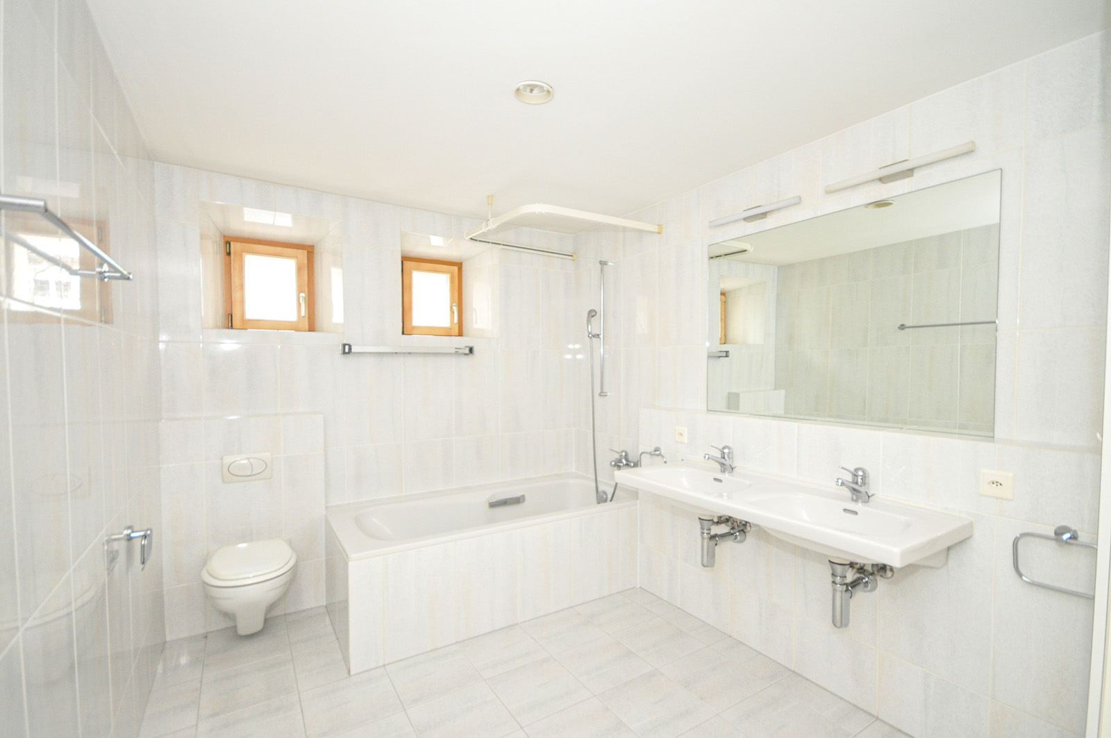 Helles Badezimmer mit Doppelwaschtisch und Wanne
