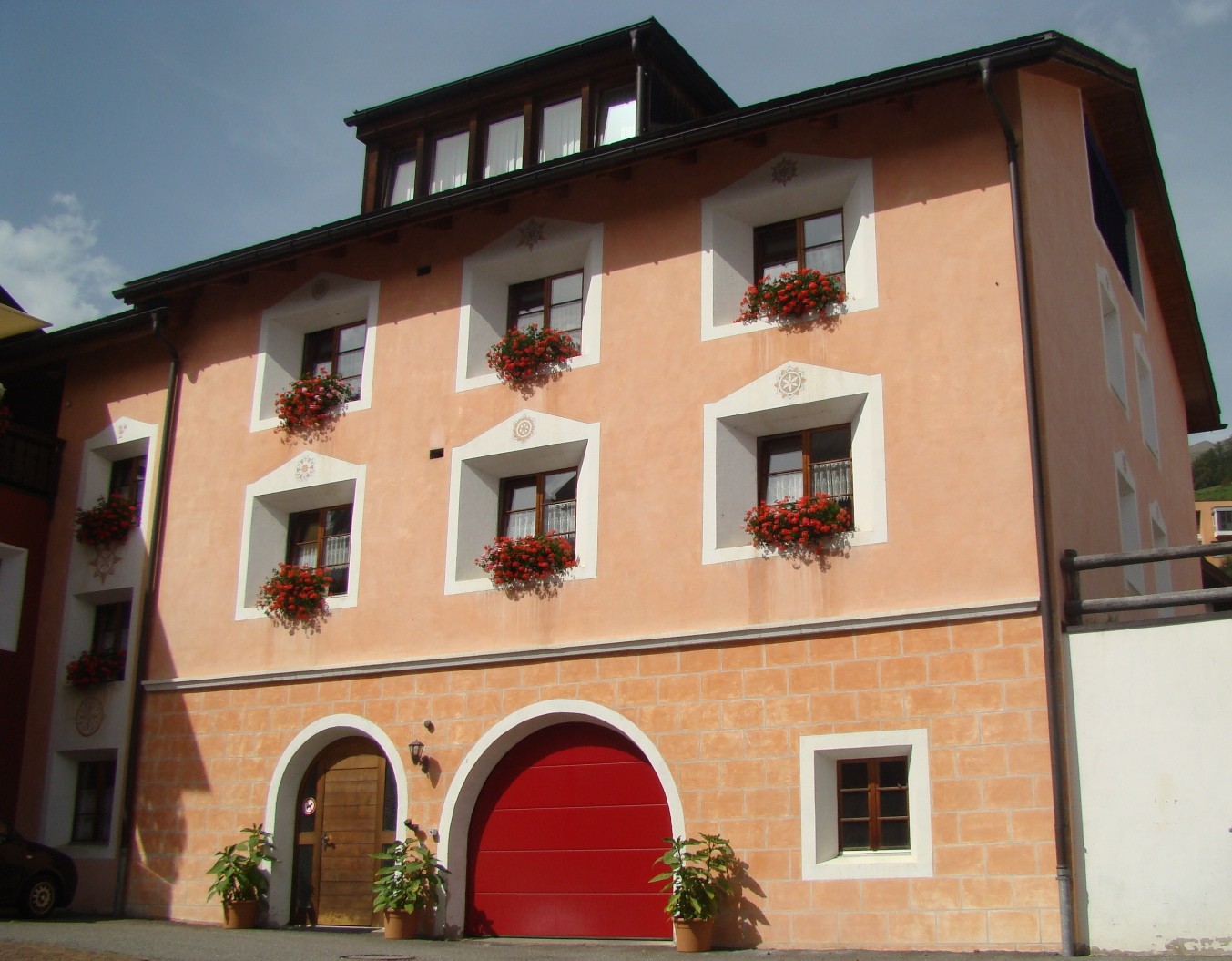 Fassade eines mehrstöckigen Hauses mit Blumenfenstern