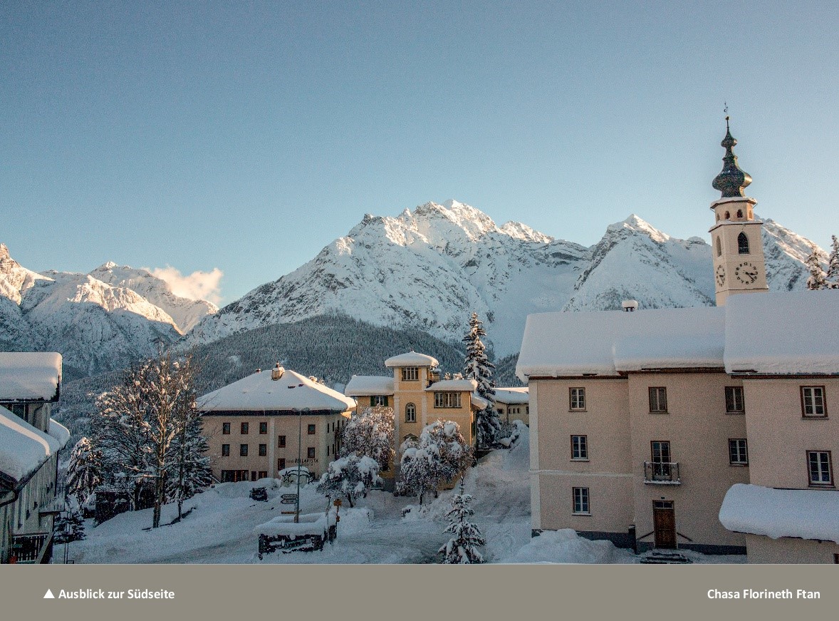 Schneebedecktes Alpenpanorama mit Dorfkirche
