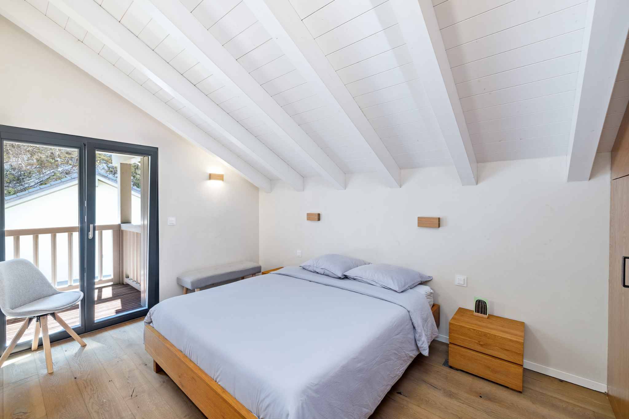 Helles Schlafzimmer mit Dachschräge und Balkonzugang