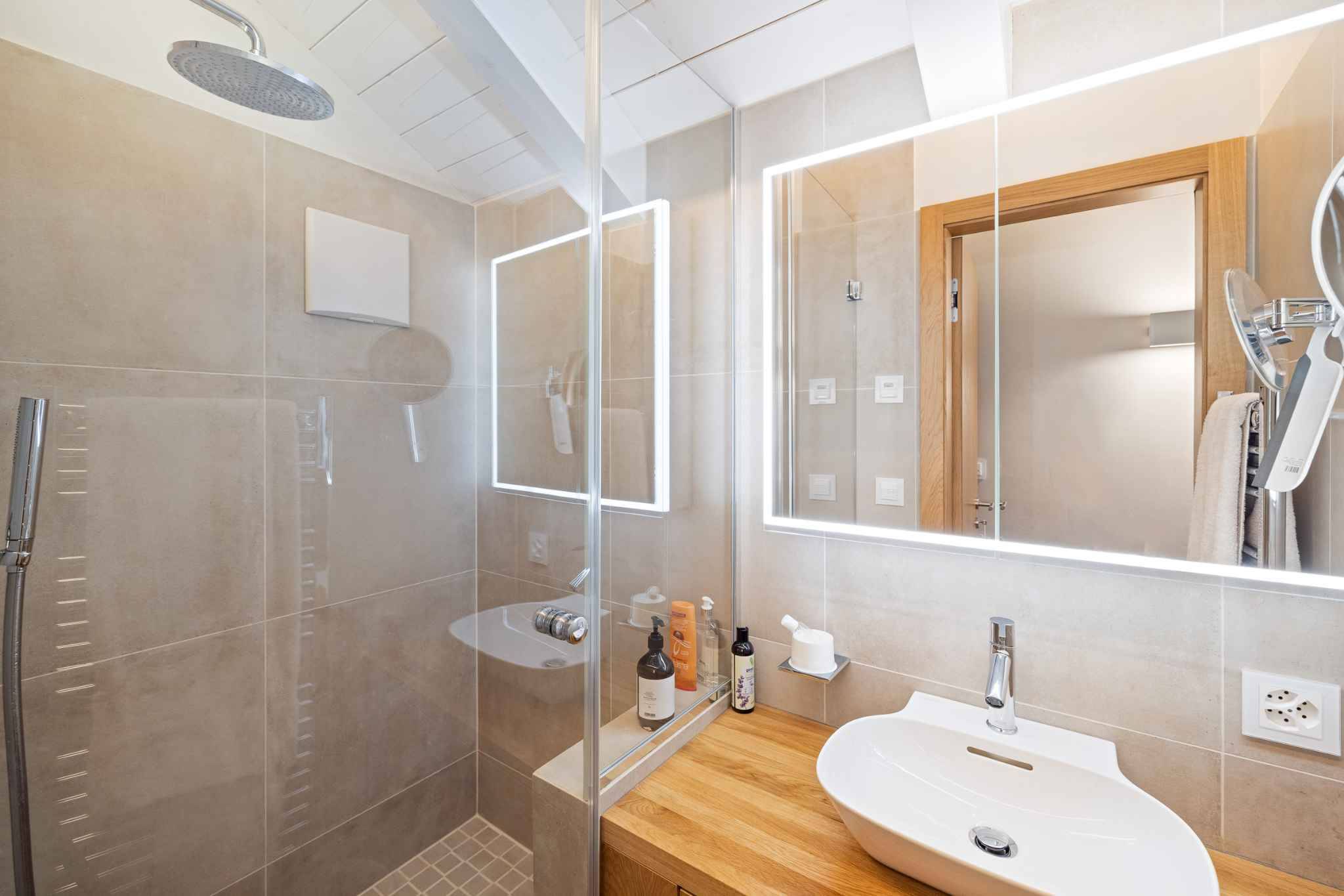 Modernes Badezimmer mit beleuchtetem Spiegel