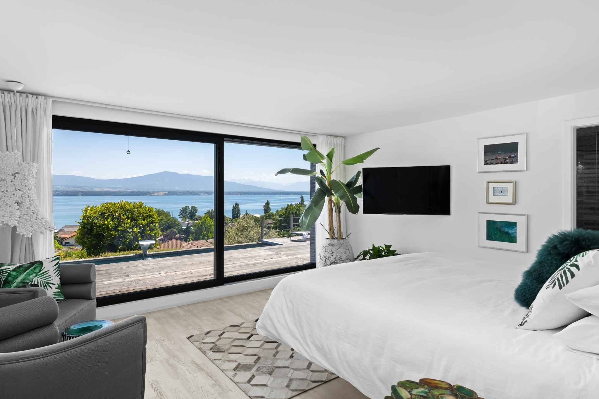 Schlafzimmer mit Panoramafenster und Seeblick