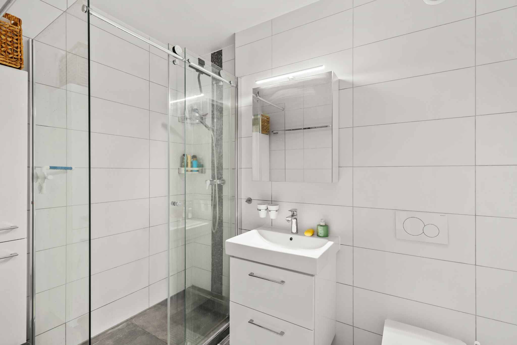Modernes Badezimmer mit Glasdusche und Waschtisch
