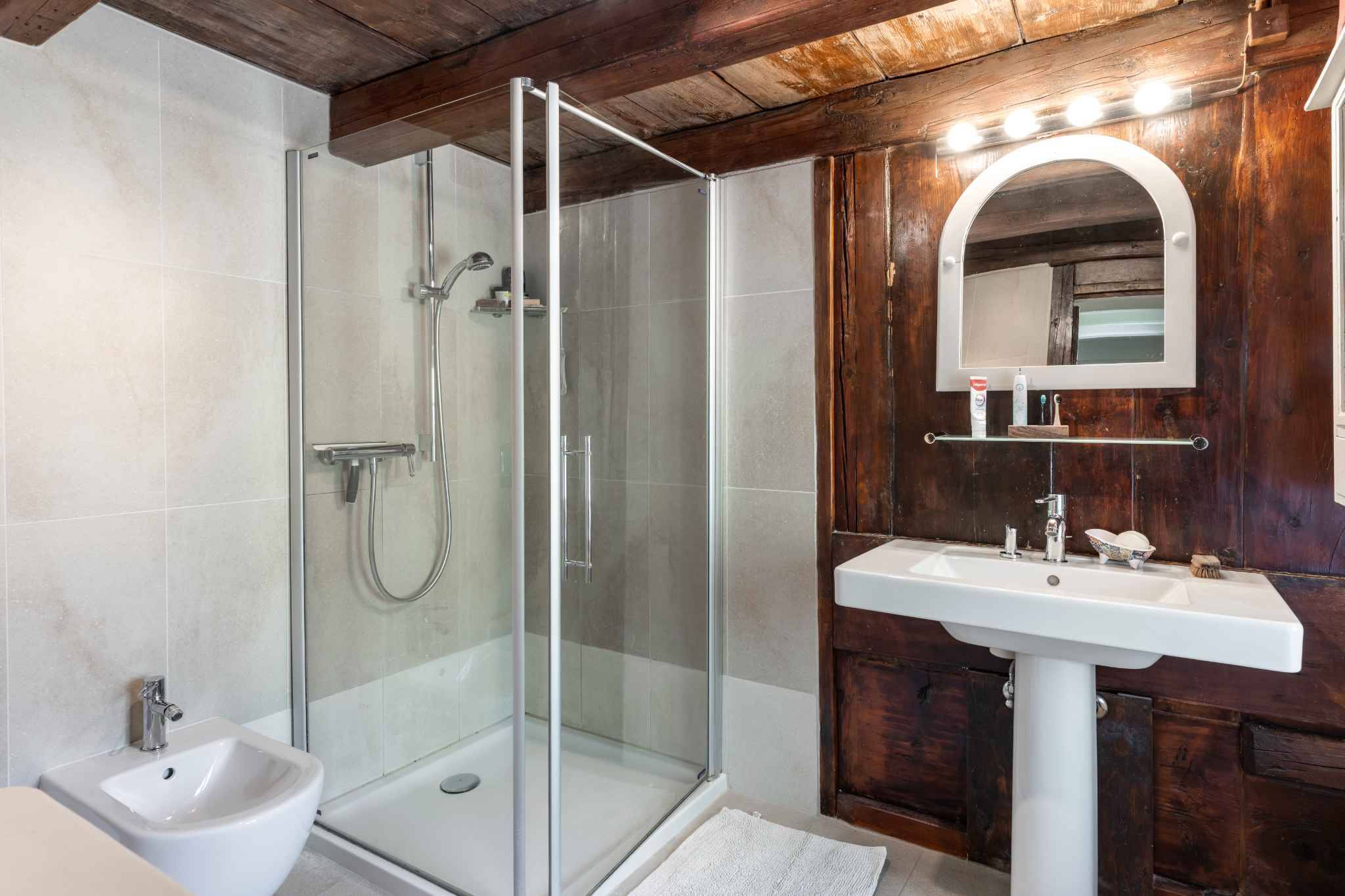 Badezimmer mit Glasdusche und Waschtisch