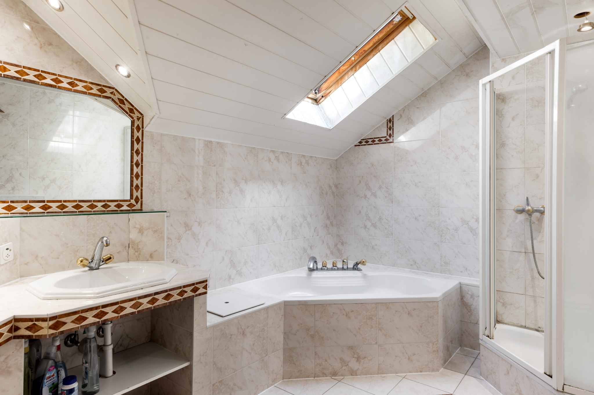 Helles Badezimmer mit Dachfenster und Badewanne